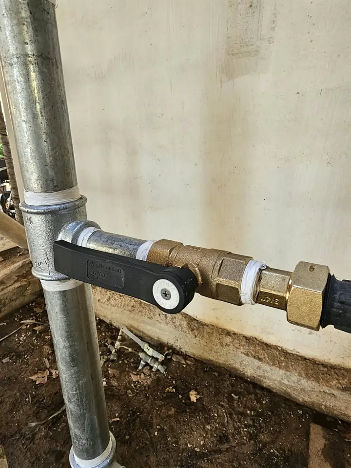 תקריב של ברז ומחברי פליז על צנרת מגולוונת חדשה במערך שעוני המים