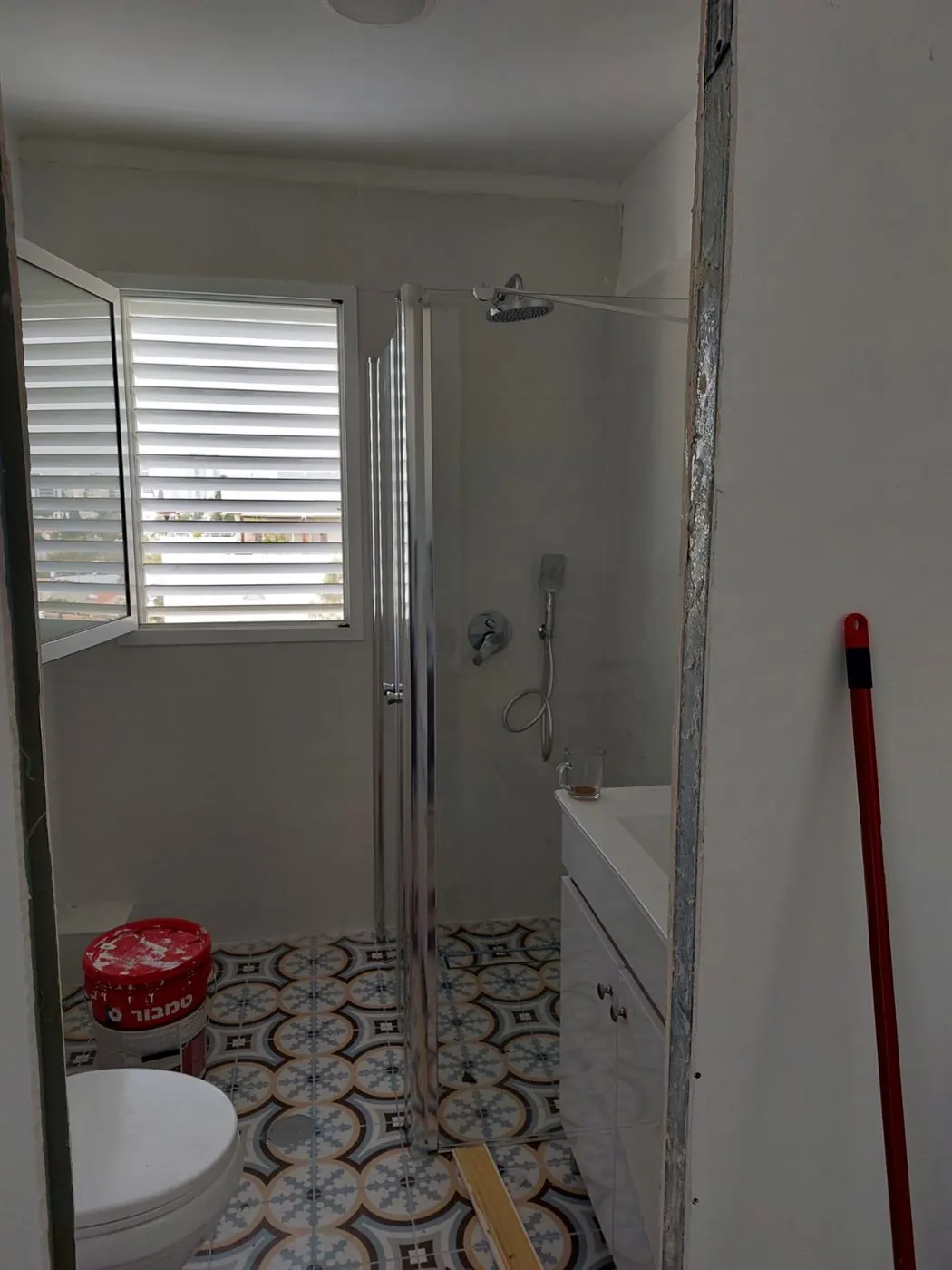 Salle de bain avec carrelage à motifs et paroi de douche